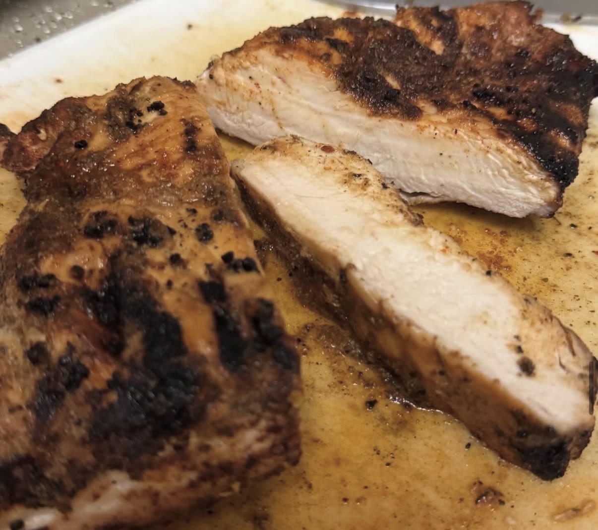 Sliced blackened chicken breast resting on a cutting board