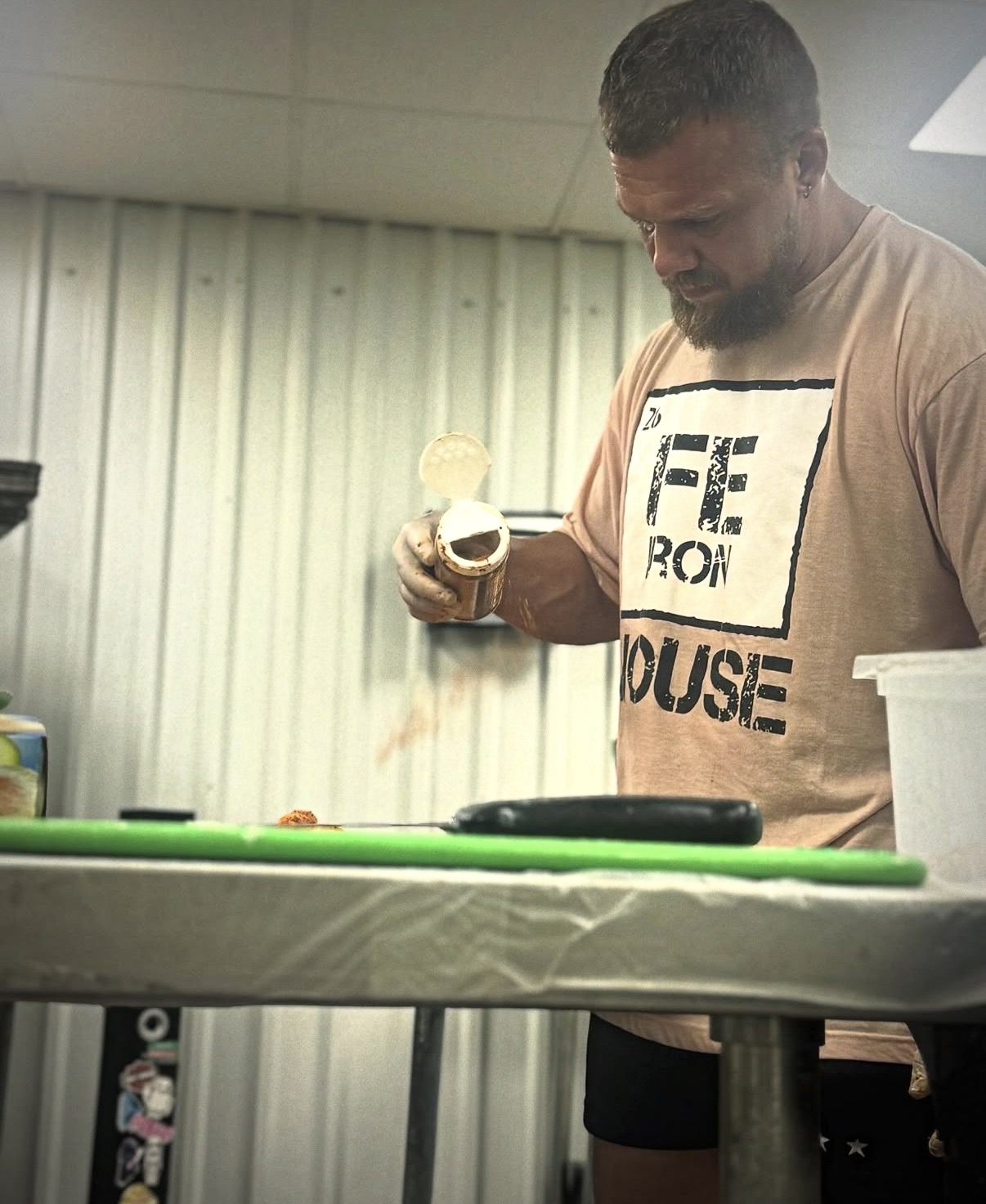 Dan seasoning chicken in the Fitness Kitchen prep area